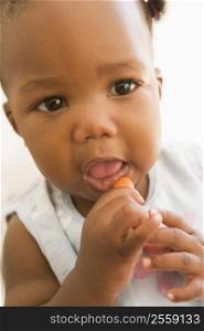 Baby eating carrot