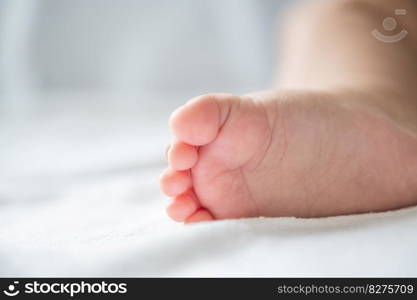 Baby feet in white bed. Selective focus.