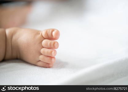 Baby feet in white bed. Selective focus.