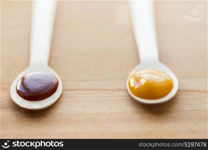 baby food, healthy eating and nutrition concept - vegetable or fruit puree in wooden spoons. vegetable or fruit puree or baby food in spoons
