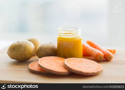 baby food, healthy eating and nutrition concept - vegetable puree in glass jar on wooden board. vegetable puree or baby food in glass jar