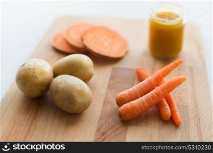 baby food, healthy eating and nutrition concept - vegetable puree in glass jar on wooden board. vegetable puree or baby food in glass jar