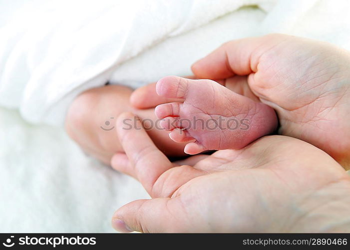 baby foot in mother hand closeup