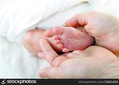 baby foot in mother hand closeup