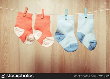 Baby girl and boy socks attached to the rope. Baby socks on rope
