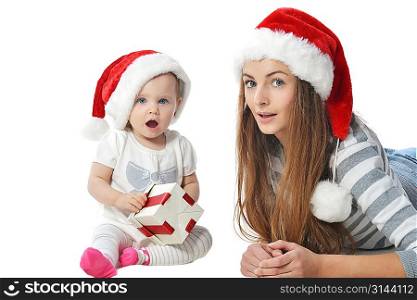 baby girl and woman in Santa Claus hat with christmas gift box