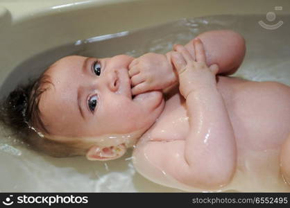 Baby girl four months old having her bath and crying