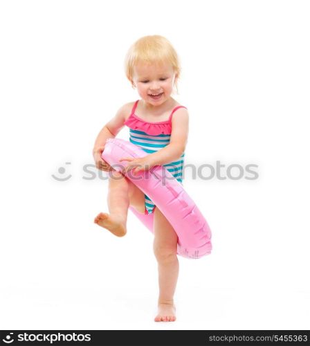 Baby girl in swimsuit playing with inflatable ring