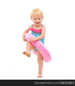 Baby girl in swimsuit playing with inflatable ring