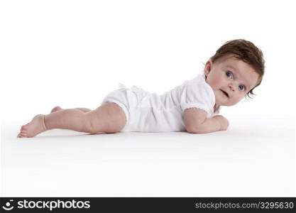 Baby girl lying on her belly full lenght on white background