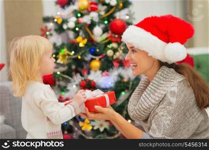 Baby girl presenting mother Christmas gift