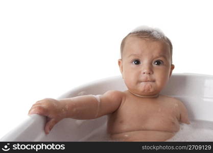 Baby girl sitting in a bathtub with foam