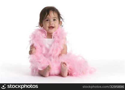Baby Girl Sitting On The Floor Dressed In Pink Feathers Like A Diva