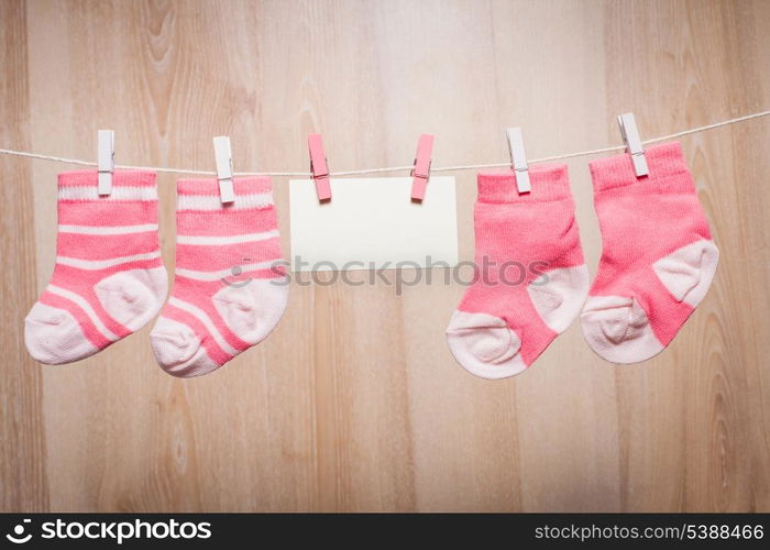 Baby girl socks attached to the rope and blank card