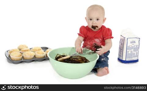 Baby girl with mixing bowl, chocolate batter, flower and muffins.