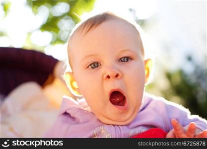 Baby girl yawns, outdoor