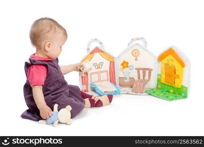Baby girls sitting on floor playing with stuffed story book. Isolated on white. Toys are officially property released.