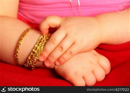 Baby hands. Baby hands, with a golden bracelet, isolated towards dark red
