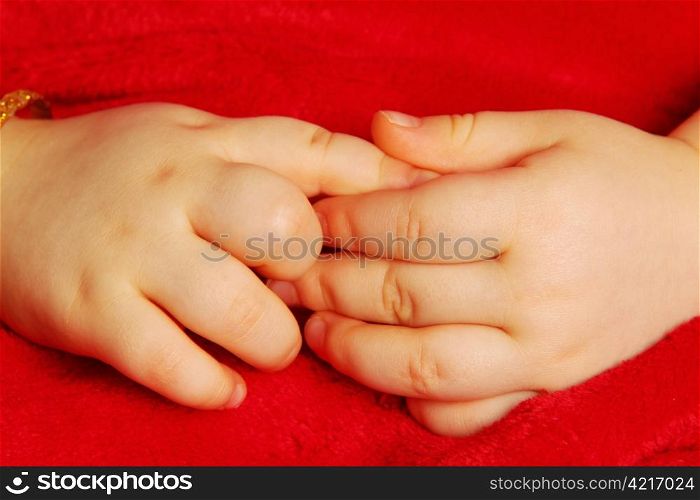 Baby hands. Baby holding hands, isolated towards dark red