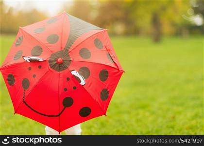 Baby hiding behind red umbrella