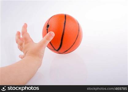 Baby holding an orange basketball model on a white background