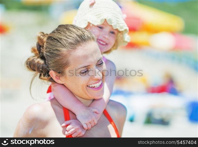 Baby hugging mother on beach