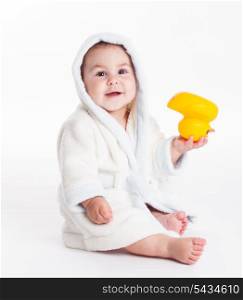 Baby in a bathrobe after a bath with yellow toy isolated
