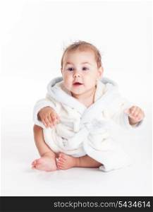 Baby in a bathrobe after bath with wet head
