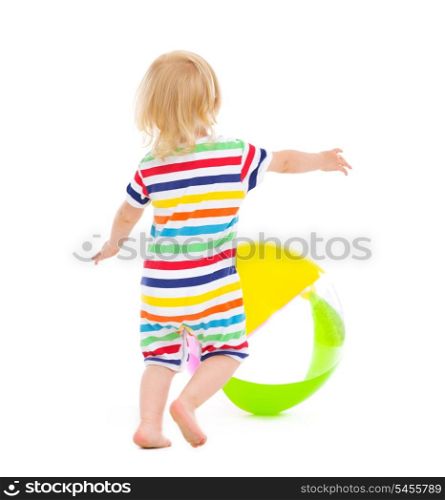 Baby in swimsuit playing with ball. Rear view