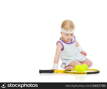 Baby in tennis clothes with racket and balls