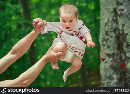 Baby in ukrainian folk dress vyshyvanka in father&rsquo;s hands&#xA;
