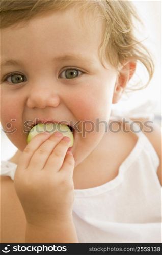 Baby indoors eating apple