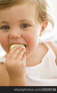 Baby indoors eating apple