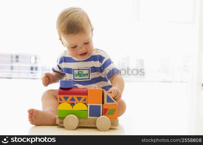 Baby indoors playing with truck