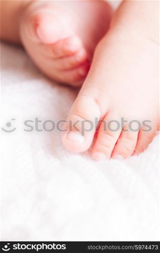 Baby is sitting on the textile. Feet close up. Baby close up foot