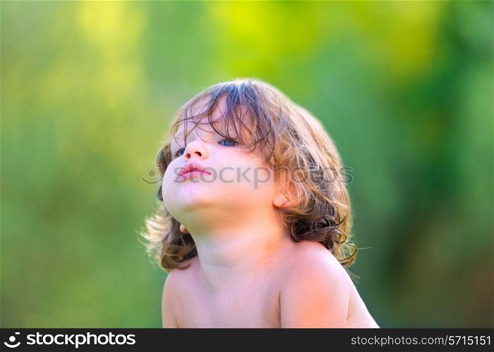 Baby kid girl in summer on green field background