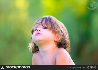 Baby kid girl in summer on green field background