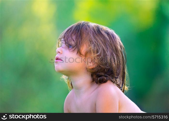 Baby kid girl profile in summer on green field background