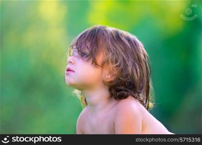 Baby kid girl profile in summer on green field background