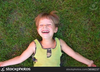 Baby laughing, lying on the grass