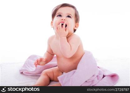 Baby laughing with open mouth sitting on a purple towel in a white isolated background