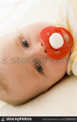 Baby lying indoors with soother