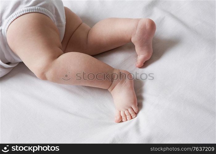 Baby lying on bed low section. Newborns
