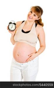 Baby on way! Smiling pregnant woman holding alarm clock isolated on white&#xA;