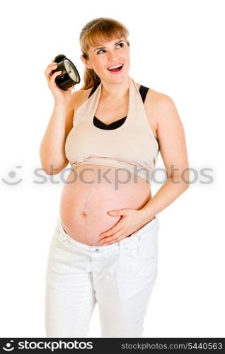 Baby on way! Smiling pregnant woman holding alarm clock isolated on white&#xA;