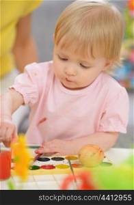 Baby painting on Easter eggs