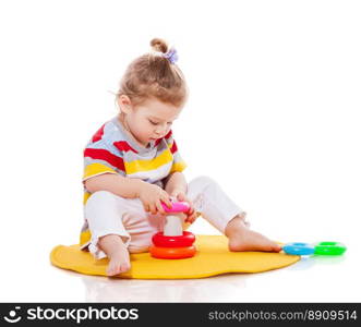 Baby playing with pyramid isolated on white. Toddler girl playing