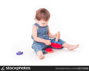 Baby playing with wooden pyramid isolated on white. Child with a toy