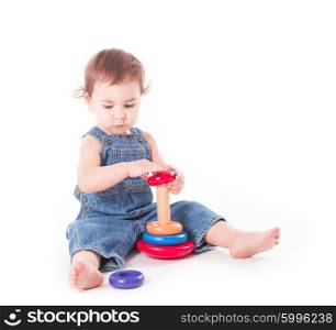 Baby playing with wooden pyramid isolated on white. Child with a toy