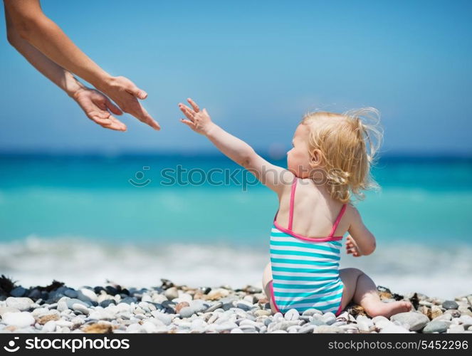 Baby pulling hands to mother